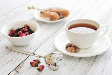 Obraz na płótnie Canvas Cup of tea with dry rose buds