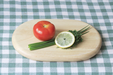 Tomato, green onion and lemon on cutting Board