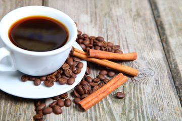 Cup of coffee, beans and cinnamon sticks