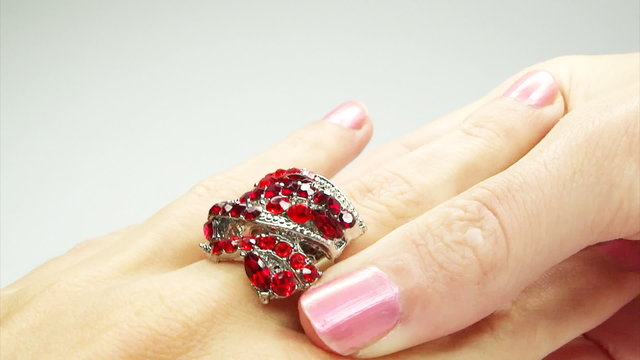 jewelery ring with red ruby crystals putting on the finger