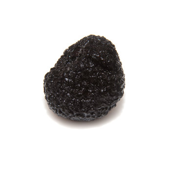 Black summer truffle isolated on a white studio background.