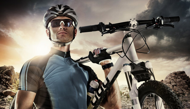 Sport. Cyclist carry a bike on dramatic sky.
