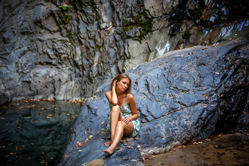 beautiful girl posing in dress at the waterfall