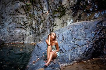 beautiful girl posing in dress at the waterfall