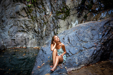 beautiful girl posing in dress at the waterfall