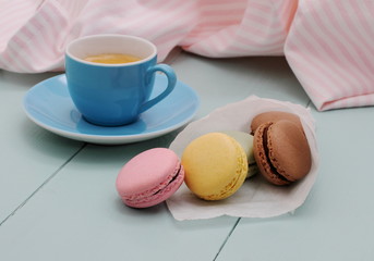 Macarons in backing paper cornet and blue Espresso cup