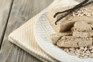 Sunflower halva on plate, on wooden background