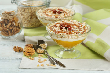 Tasty dessert with oat flakes and honey, on table