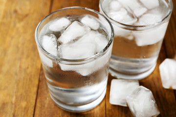 Summer cocktail with ice cubes on wooden table