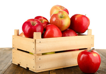 Crate of apples on wooden table, isolated on white background