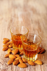 Dessert liqueur Amaretto with almond nuts, on wooden table