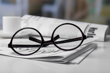 Glasses and newspapers, close-up
