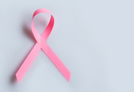 Pink breast cancer ribbon on grey background
