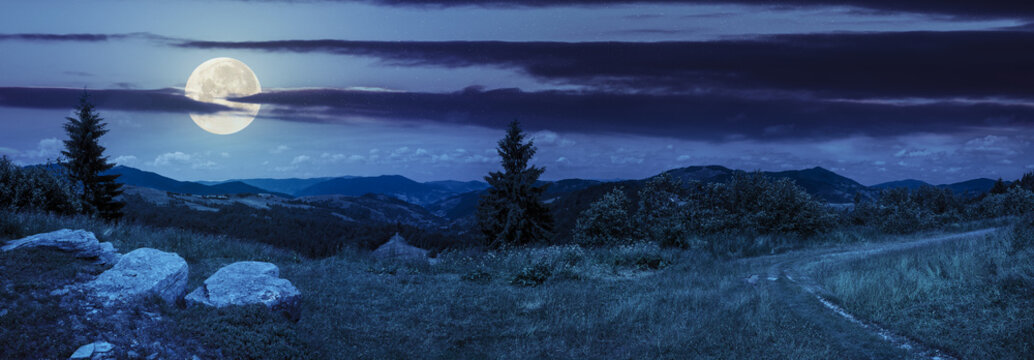 boulders on hillside meadow in mountain at night