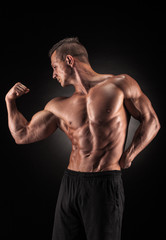 Obraz na płótnie Canvas Muscular man on black background