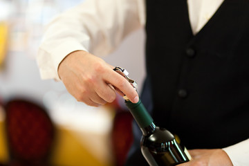 Waiter uncorking a wine bottle