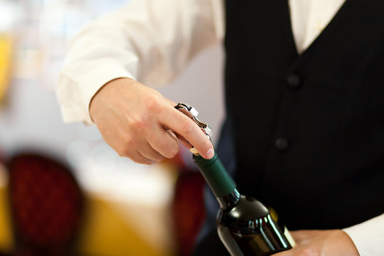 Waiter Uncorking A Wine Bottle