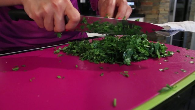 Woman chopping cilantro with a knife