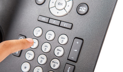 Female hand dialing numbers of desktop telephone 