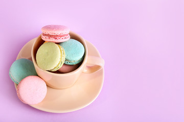 Assortment of gentle colorful macaroons in colorful mug