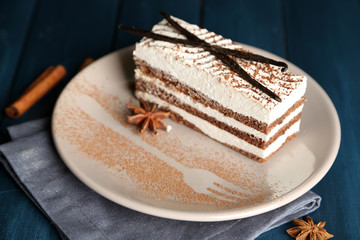Tasty tiramisu cake on plate, on wooden table