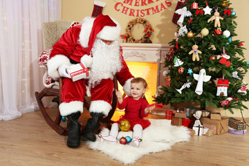 Santa Claus giving  present to  little cute girl near