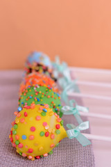 Sweet cake pops on table on beige background