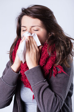 Woman in scarf sneezing