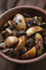 Roasted unpeeled potato with mushrooms, close-up, studio shot