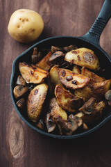 Close-up of roasted potatoes with champignons in a frying pan