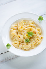 Glass plate with tortellini in bouillon, studio shot, close-up