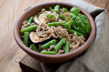 Soba noodles with aubergine, beans and sesame, close-up