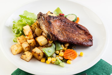 Fried pork with potatoes and vegetables salad
