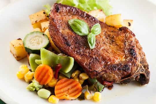 Fried pork with potatoes and vegetables salad