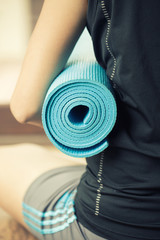 Young woman holding a yoga mat