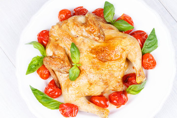 Roast chicken with tomatoes cherry, green basil and garlic