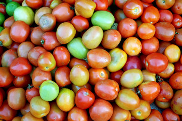 Fototapeta na wymiar Background of local tomatoes for sale at a market