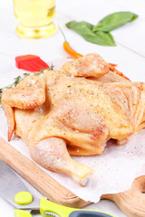 Fresh raw chicken prepared for roast with thyme and tomatoes