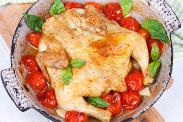 Roast chicken with tomatoes cherry, green basil and garlic