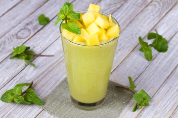 Fresh mango fruit juice in a glass and slices of mango