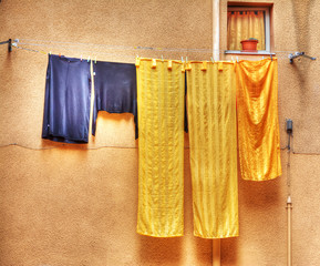 yellow and blue clothes hanging on a laundry line in hdr