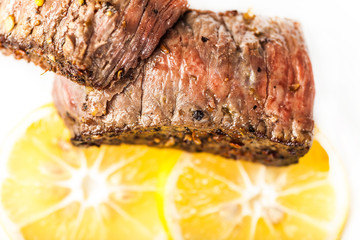 Sliced fried meat with slices of lemon closeup