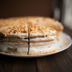 Homemade honey cake with cut piece on a table