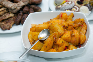 Fried potato wedges on white plate