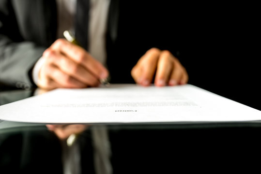 Businessman signing a document with focus to the text Contract