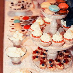 Sweet colorful buffet table with macaroons and cakes