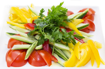 tomatoes and peppers sliced on a white plate