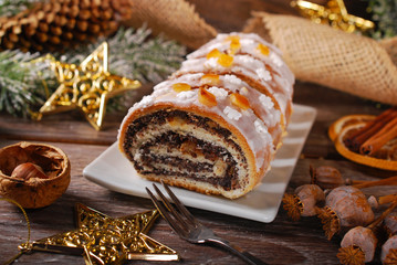 sliced christmas poppy seed cake with icing and snowflake sprink