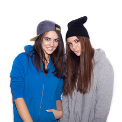 Two girlfriends standing together smiling and flirting