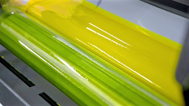 Yellow Paint Running Off a Roller in Offset Printing Press